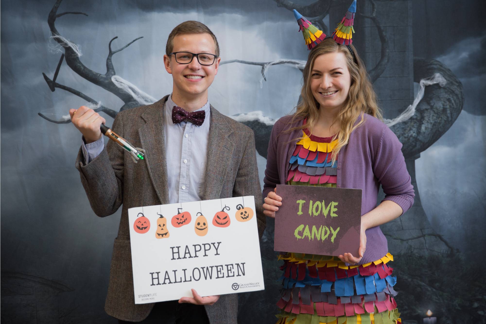 Bobby Nielsen and Kell arrand holding signs labeled "Happy Halloween" & "I love candy"